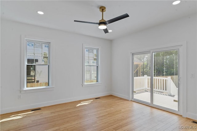 unfurnished room with ceiling fan, a healthy amount of sunlight, and light wood-type flooring