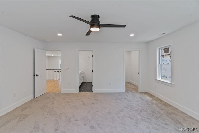 unfurnished bedroom featuring a spacious closet, ceiling fan, ensuite bathroom, and light colored carpet