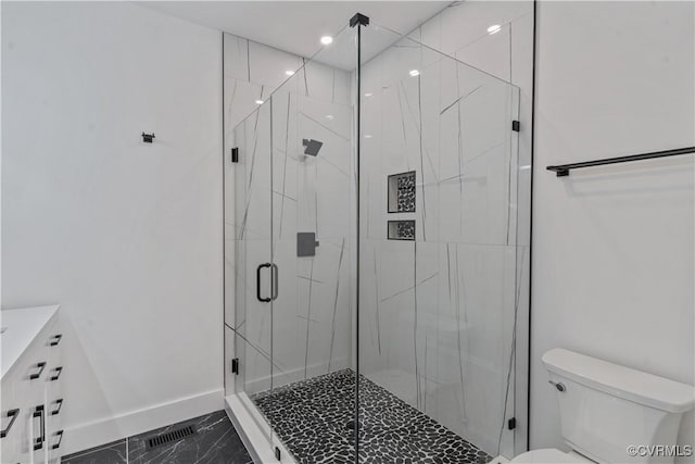 bathroom with toilet, a shower with door, and vanity