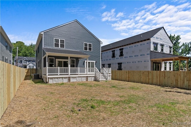 rear view of house featuring cooling unit and a yard