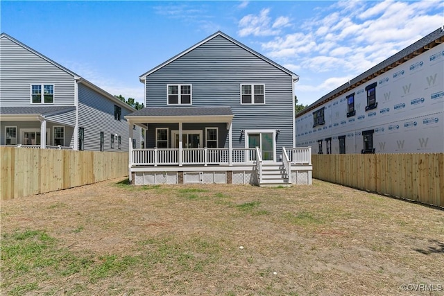 back of property with a deck and a yard