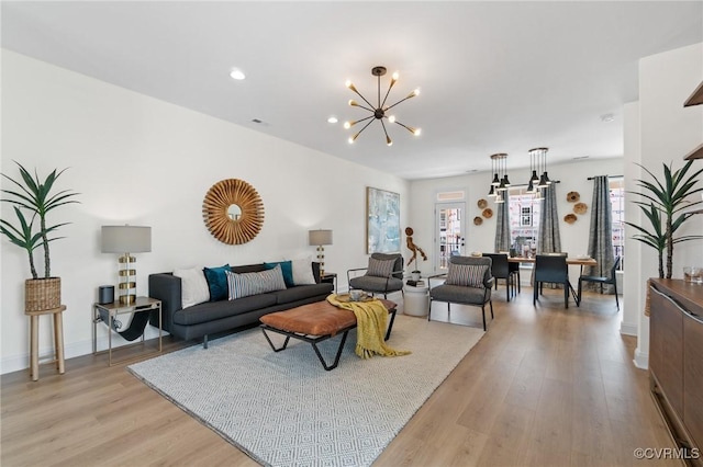 living room featuring a notable chandelier and light hardwood / wood-style floors