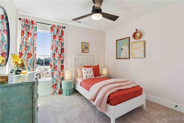 carpeted bedroom with baseboards, visible vents, and a ceiling fan