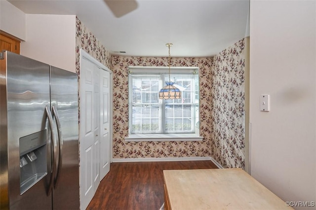 kitchen with dark hardwood / wood-style flooring, stainless steel fridge, and hanging light fixtures