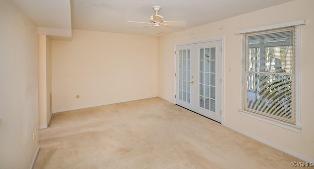 unfurnished room with ceiling fan, light colored carpet, and french doors