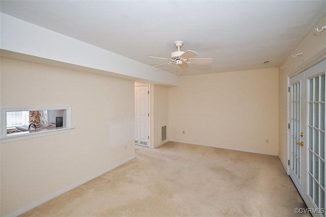 basement with ceiling fan, light colored carpet, and sink