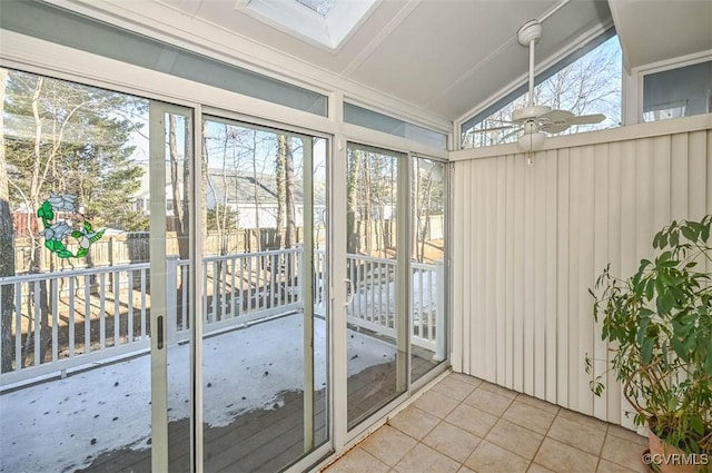 unfurnished sunroom featuring ceiling fan and lofted ceiling with skylight