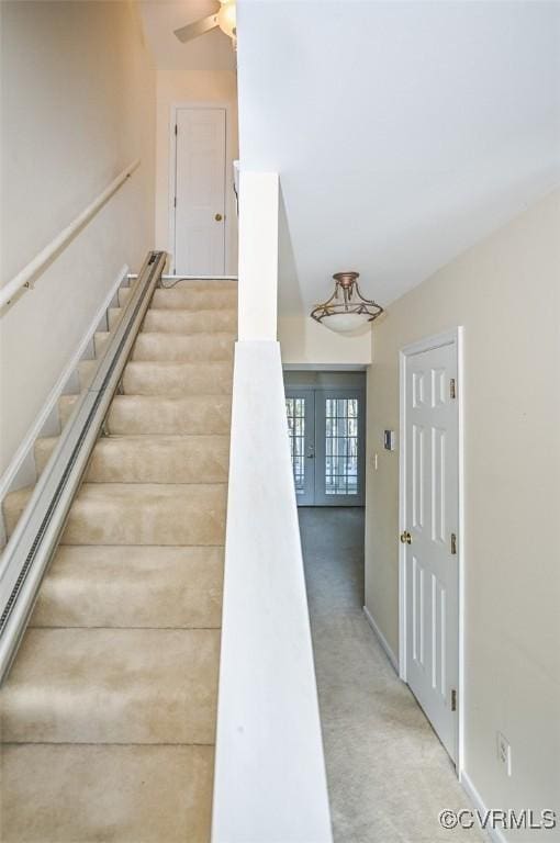 stairs featuring carpet floors, french doors, and ceiling fan