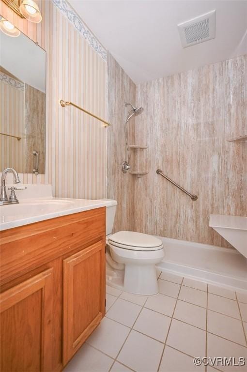 bathroom with toilet, vanity, tile patterned floors, and walk in shower