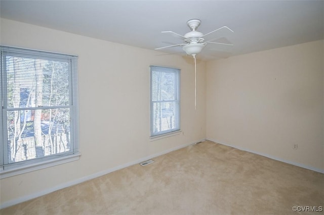 empty room with ceiling fan and light colored carpet