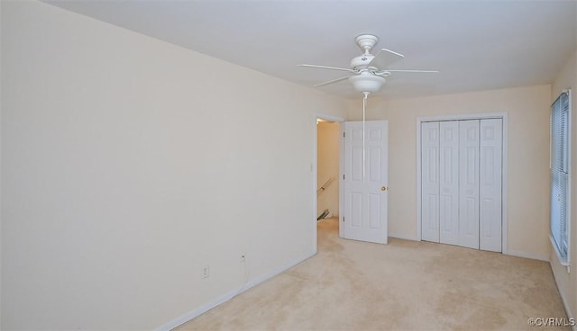 unfurnished bedroom with ceiling fan, a closet, and light carpet