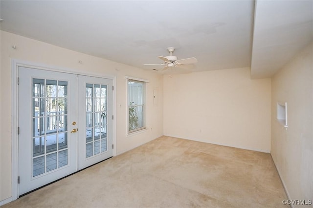 carpeted spare room featuring ceiling fan and french doors