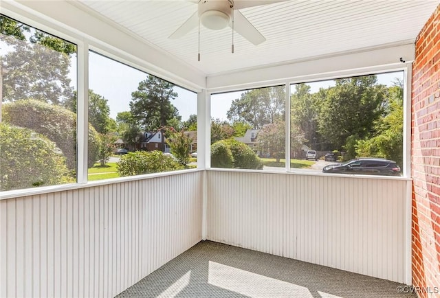 unfurnished sunroom featuring ceiling fan