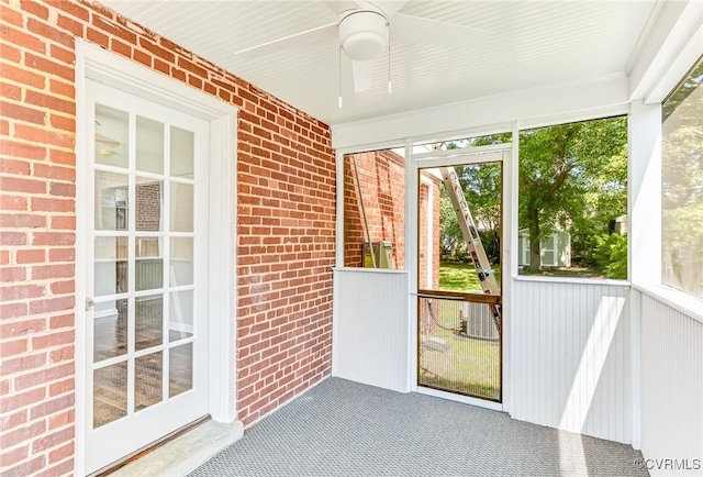 unfurnished sunroom with ceiling fan