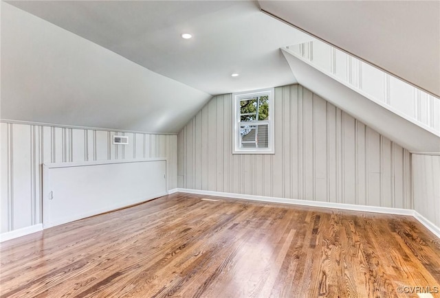 bonus room with vaulted ceiling and wood-type flooring