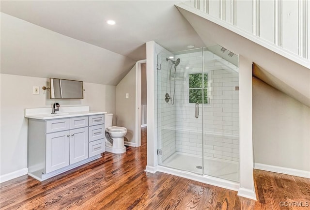 bathroom with toilet, lofted ceiling, wood-type flooring, an enclosed shower, and vanity