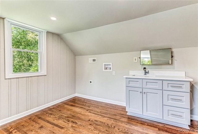 interior space with sink, washer hookup, electric dryer hookup, and hardwood / wood-style flooring