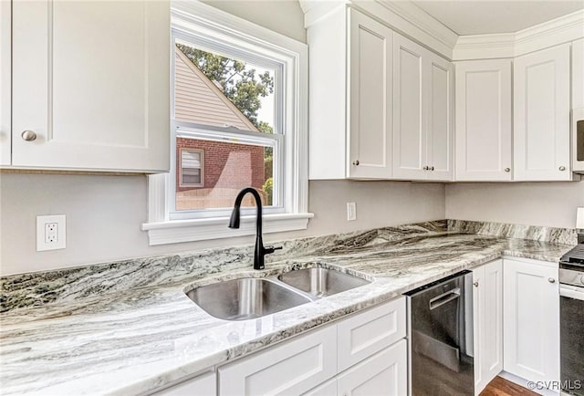 kitchen featuring light stone countertops, sink, white cabinetry, and plenty of natural light