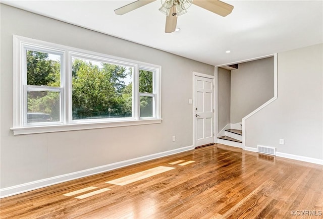 empty room with ceiling fan and light hardwood / wood-style flooring