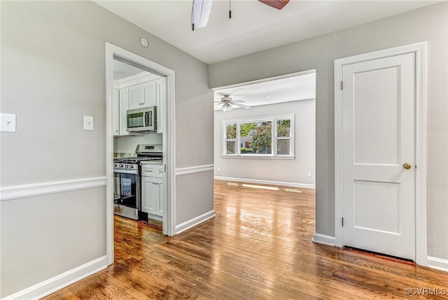 kitchen featuring ceiling fan, stainless steel appliances, and hardwood / wood-style flooring