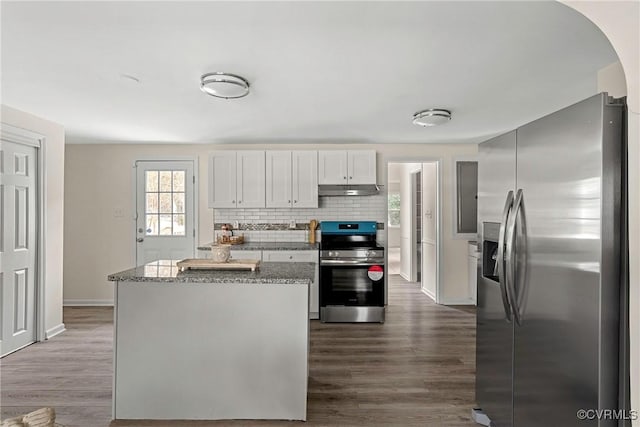 kitchen with backsplash, dark hardwood / wood-style floors, appliances with stainless steel finishes, white cabinets, and dark stone counters