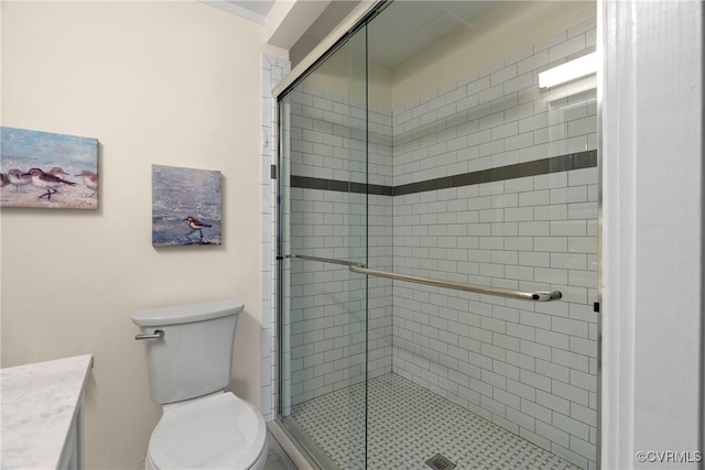 bathroom featuring toilet, ornamental molding, a shower with shower door, and vanity