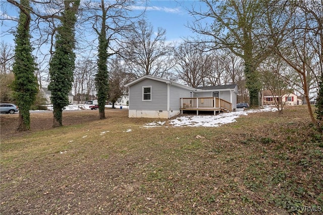 back of house with a deck and a yard