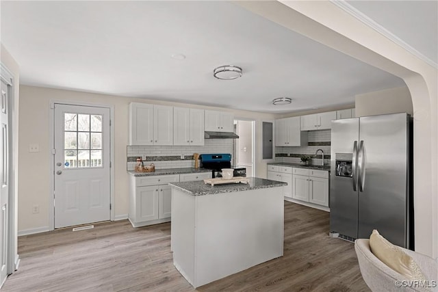 kitchen featuring stainless steel fridge, sink, white cabinetry, and range with electric cooktop