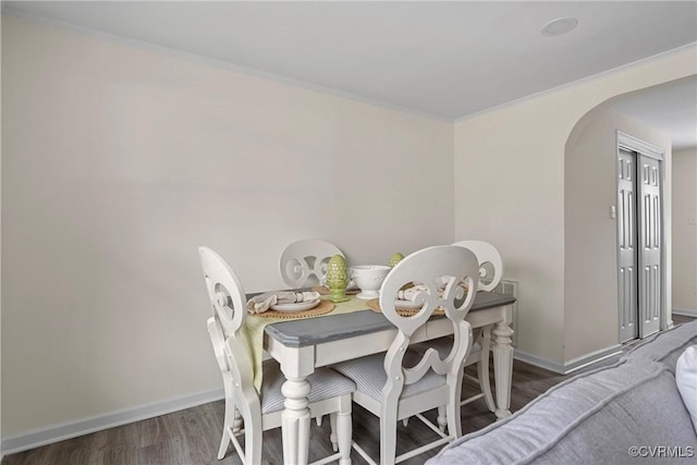 dining room with dark wood-type flooring and crown molding