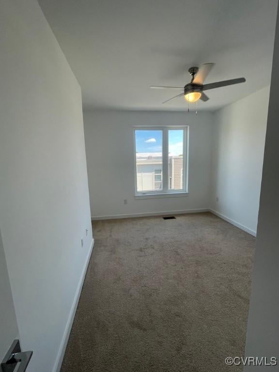 carpeted spare room featuring ceiling fan