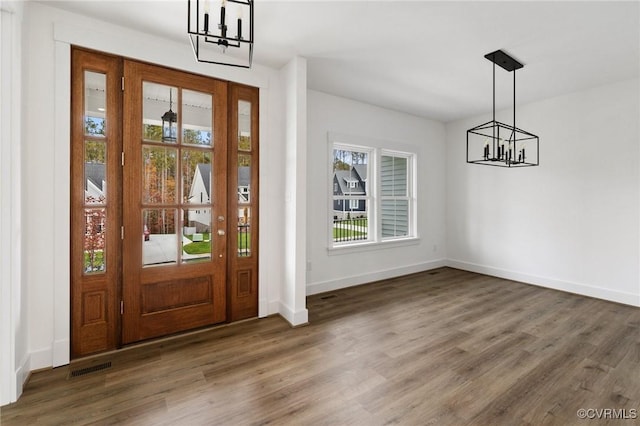 foyer entrance featuring dark hardwood / wood-style floors and a notable chandelier