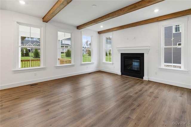 unfurnished living room featuring beam ceiling and hardwood / wood-style floors