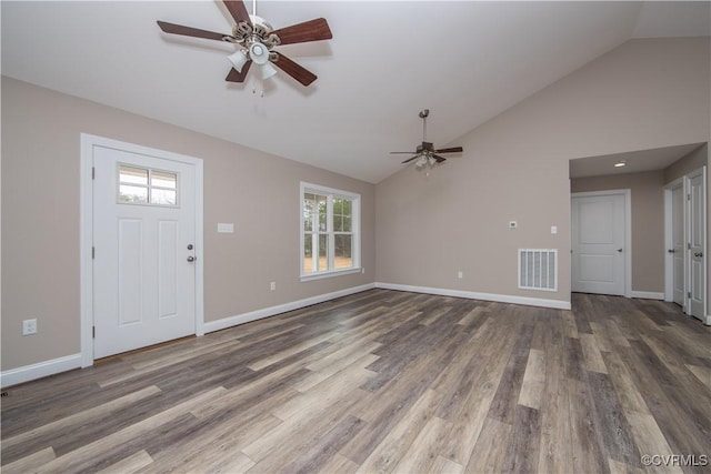 unfurnished living room with vaulted ceiling, plenty of natural light, and dark hardwood / wood-style floors