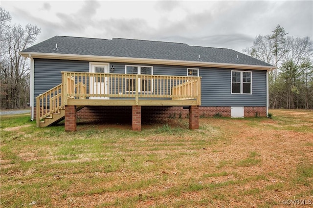 rear view of house featuring a wooden deck and a lawn