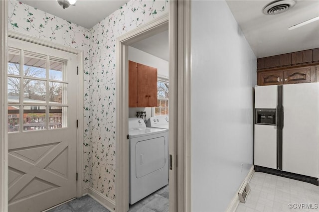 laundry room with washing machine and dryer, cabinets, and a wealth of natural light