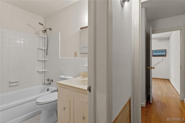 full bathroom with toilet, vanity, tile walls, an AC wall unit, and tiled shower / bath combo