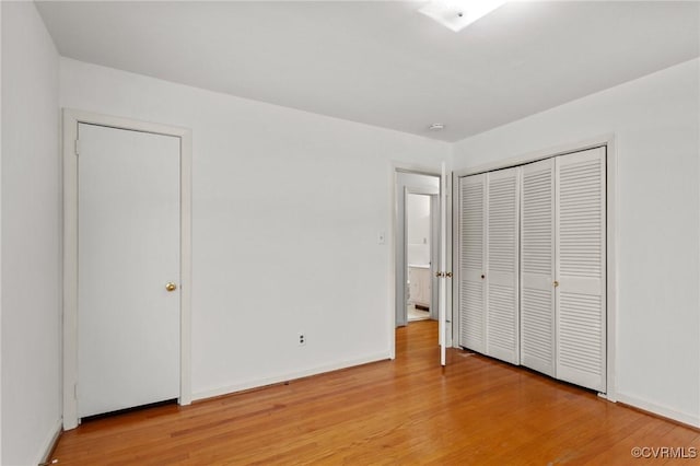 unfurnished bedroom featuring a closet and light hardwood / wood-style floors