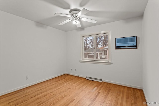 empty room with ceiling fan, a wall unit AC, and light hardwood / wood-style flooring