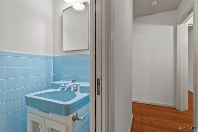 bathroom featuring hardwood / wood-style flooring, tile walls, and vanity