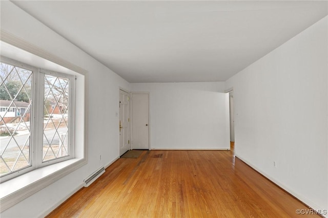 empty room featuring light wood-type flooring and plenty of natural light