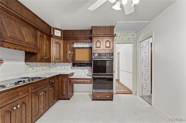 kitchen featuring white gas stovetop, custom exhaust hood, black double oven, tasteful backsplash, and ceiling fan