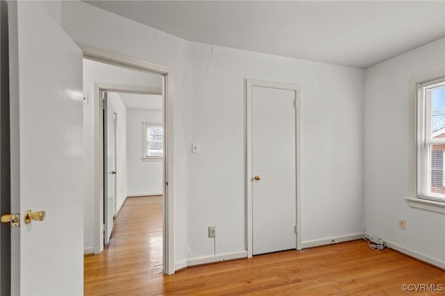 unfurnished bedroom with multiple windows and light hardwood / wood-style flooring