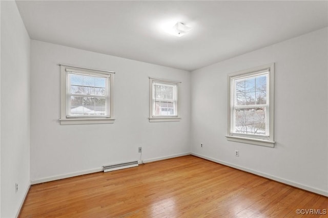 unfurnished room featuring light hardwood / wood-style floors and a baseboard radiator