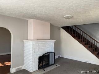 unfurnished living room with a fireplace and a textured ceiling