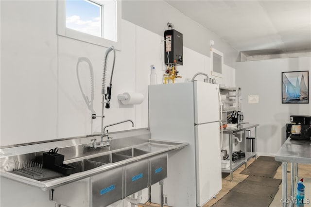 kitchen with water heater, white refrigerator, and white cabinets