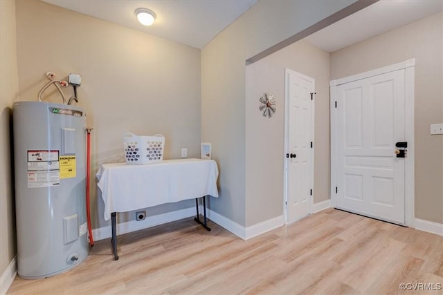 interior space with water heater, washer hookup, and light wood-type flooring