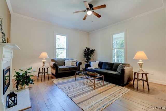 living room featuring light wood-type flooring, ceiling fan, and crown molding