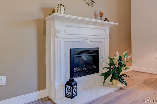 details featuring hardwood / wood-style floors and a tile fireplace