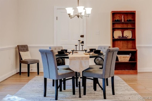 dining area featuring light wood-type flooring and a chandelier