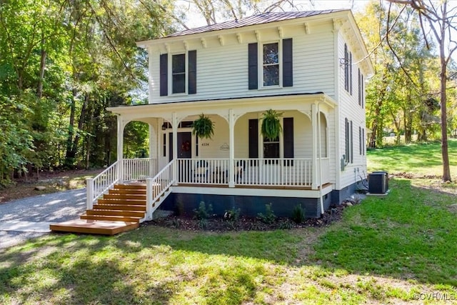 view of front of property featuring a front lawn, central AC unit, and a porch